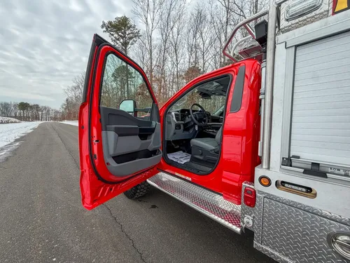 Open driver door showing step-in area and front seat.
